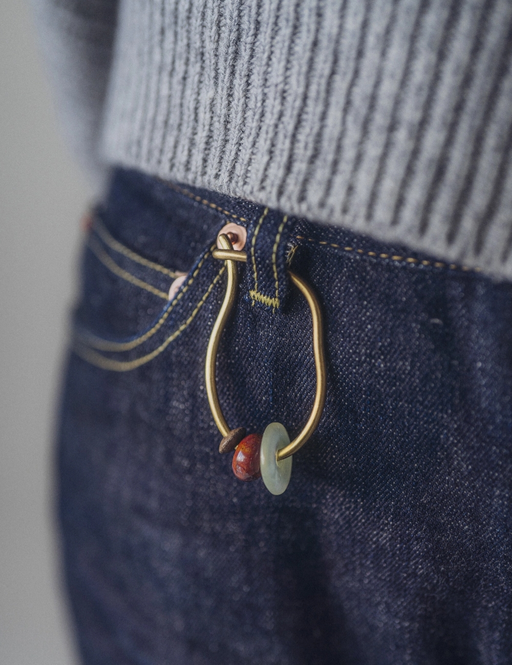 ジーンズのベルト通しにキーリングを付けている様子